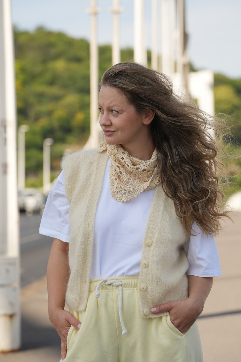 Kobieta patrząca w bok w kamizelce i chuście zawiązanej na szyi Sirka handmade