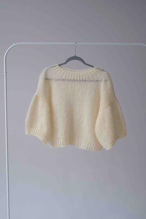 Wełniany, cytrynowy sweter Sirka&PG Clothes na wieszaku