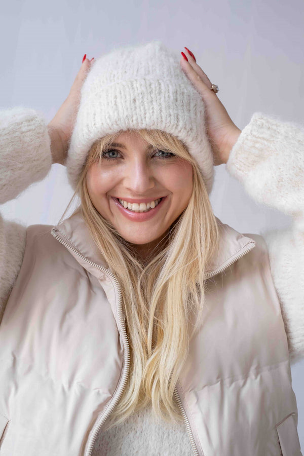 Uśmiechnięta kobieta w czapce Tiya z alpaki suri z merynosem w naturalnym odcieniu