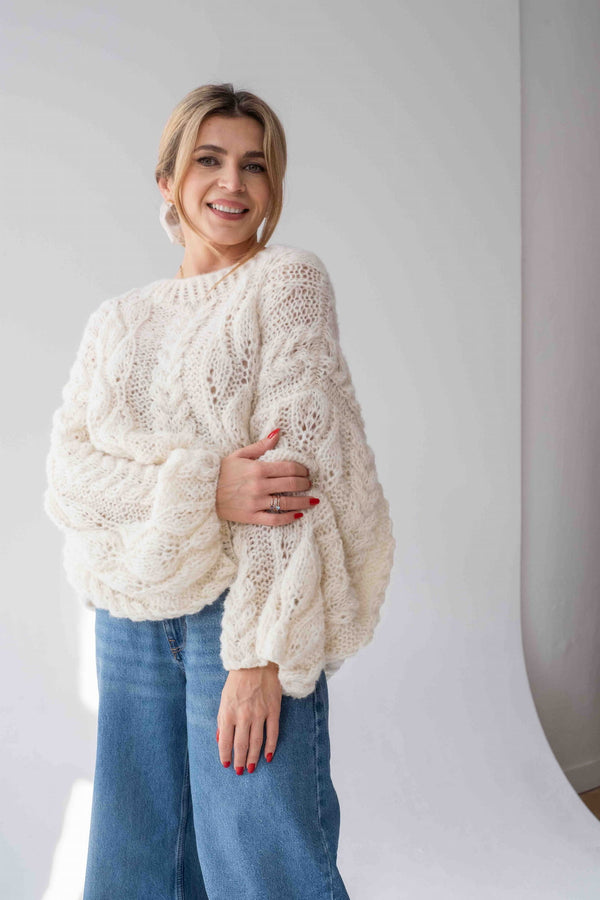 Uśmiechnięta kobieta w swetrze z alpaki Sirka w odcieniu naturalnym