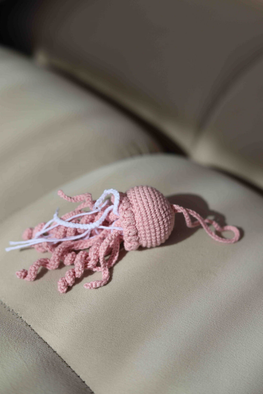 Różowy brelok meduzka leżacy na kanapie Sirka handmade