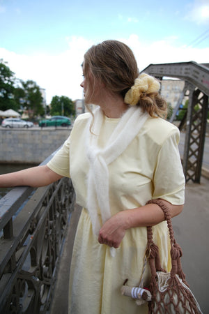 Kobieta stojąca przy mostku patrząca w dal z wlosami spiętymi w kucyk gumką scrunchie Sirka handmade