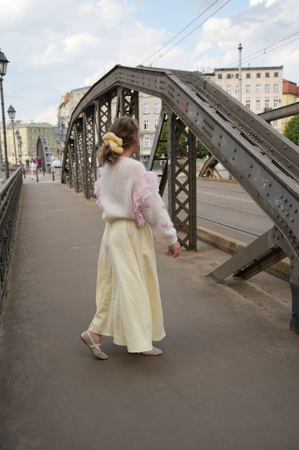 Kobieta stojąca tyłem przy moście w swetrze, sukience z włosami spietymi w kucyk gumką do włosów Sirka handmade