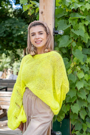 Uśmiechnięta kobieta w neonowym swetrze Lia z suri alpaki Sirka