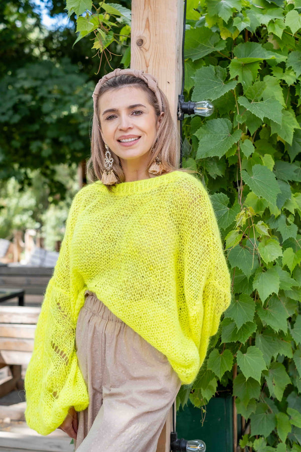 Uśmiechnięta kobieta w neonowym swetrze Lia z suri alpaki Sirka