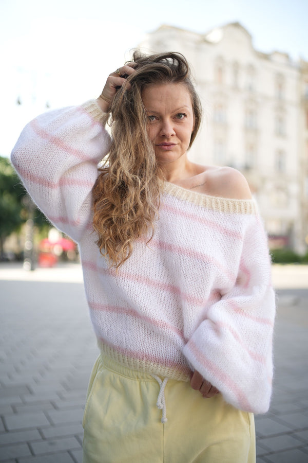 Kobieta poprawiająca włosy w swetrze z paseczkami Sirka handmade