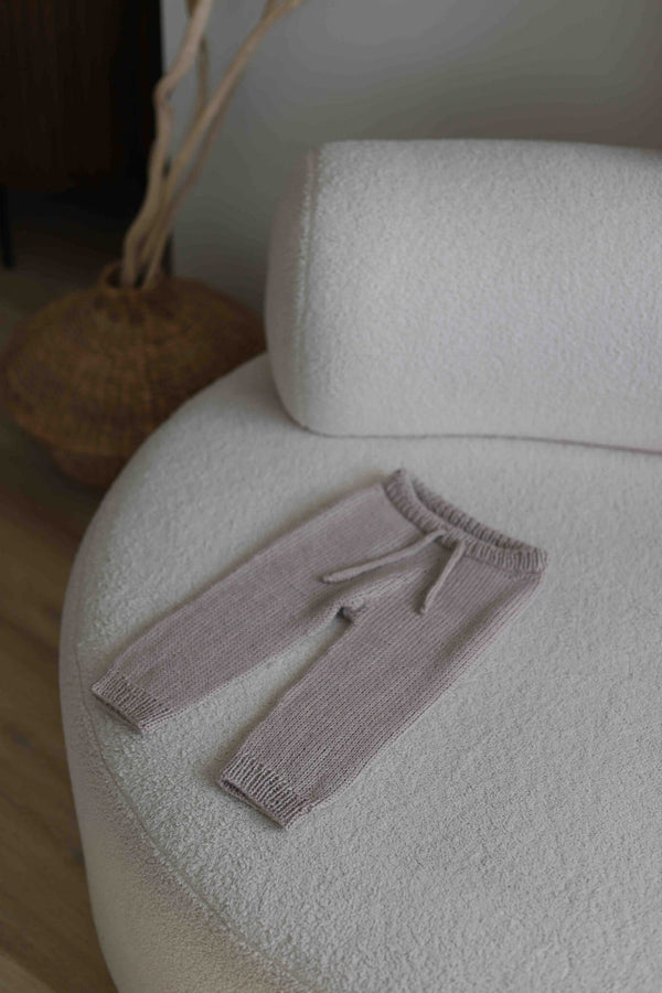 Dziecięce spodenki ręcznie dziergane leżące na kanapie Sirka handmade