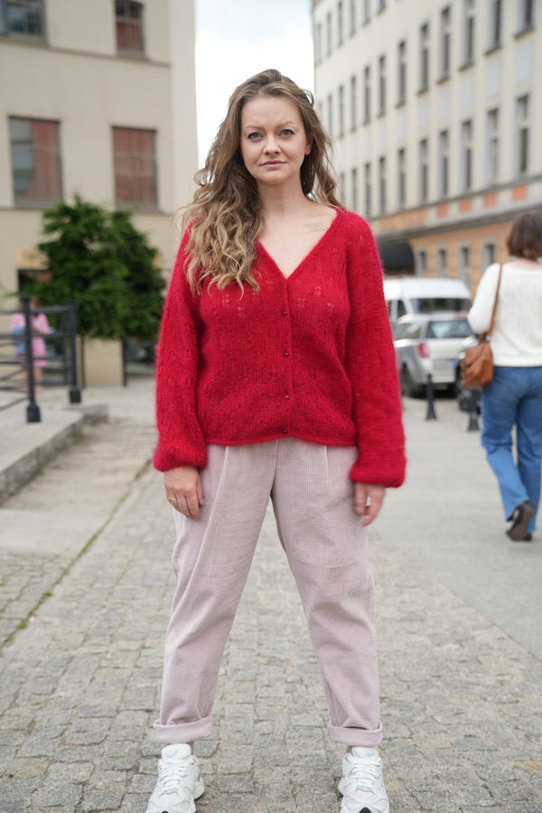 Kobieta stojąca na chodniku w czerwonym kardiganie SIrka handmade