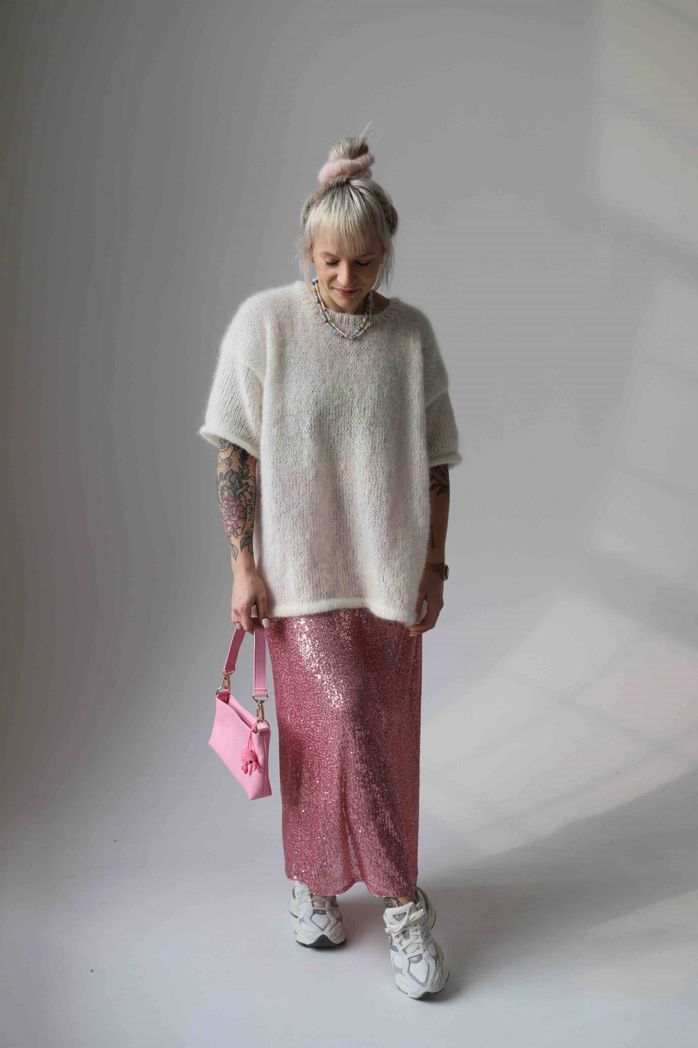 Kobieta patrząca w dół w wełnianym t-shircie Sirka handmade w odcieniu ecru