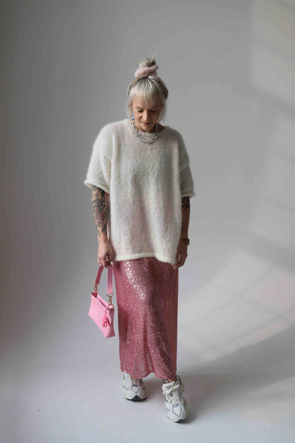 Kobieta patrząca w dół w wełnianym t-shircie Sirka handmade w odcieniu ecru