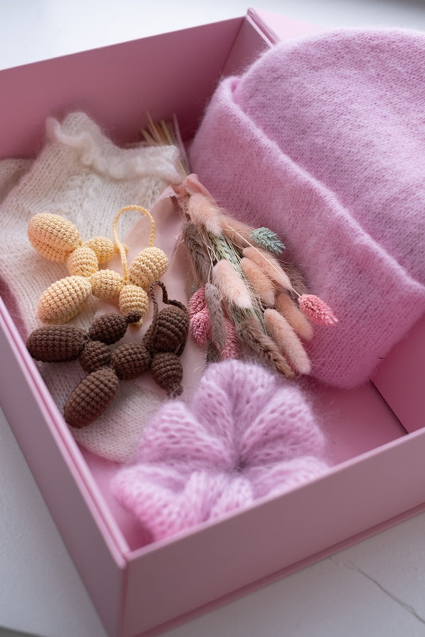 Pudełko z suszkiem kwiatów, czapką, breloczkami i gumką do włosów