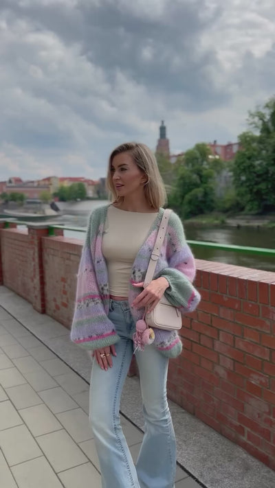 Kobieta na tle miasta prezentująca kolorowy kardigan Izabella Sirka handmade 