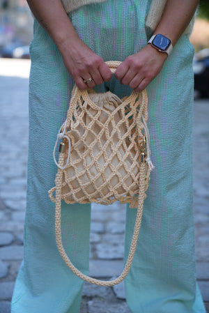 Kobieta trzymająca w ręku torebkę sznurkową Wiki w odcieniu masełkowym Sirka handmade