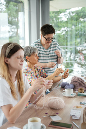 Kobiety na warsztatach Sirka handmade robiące gumki do włosów na drutach w sali 